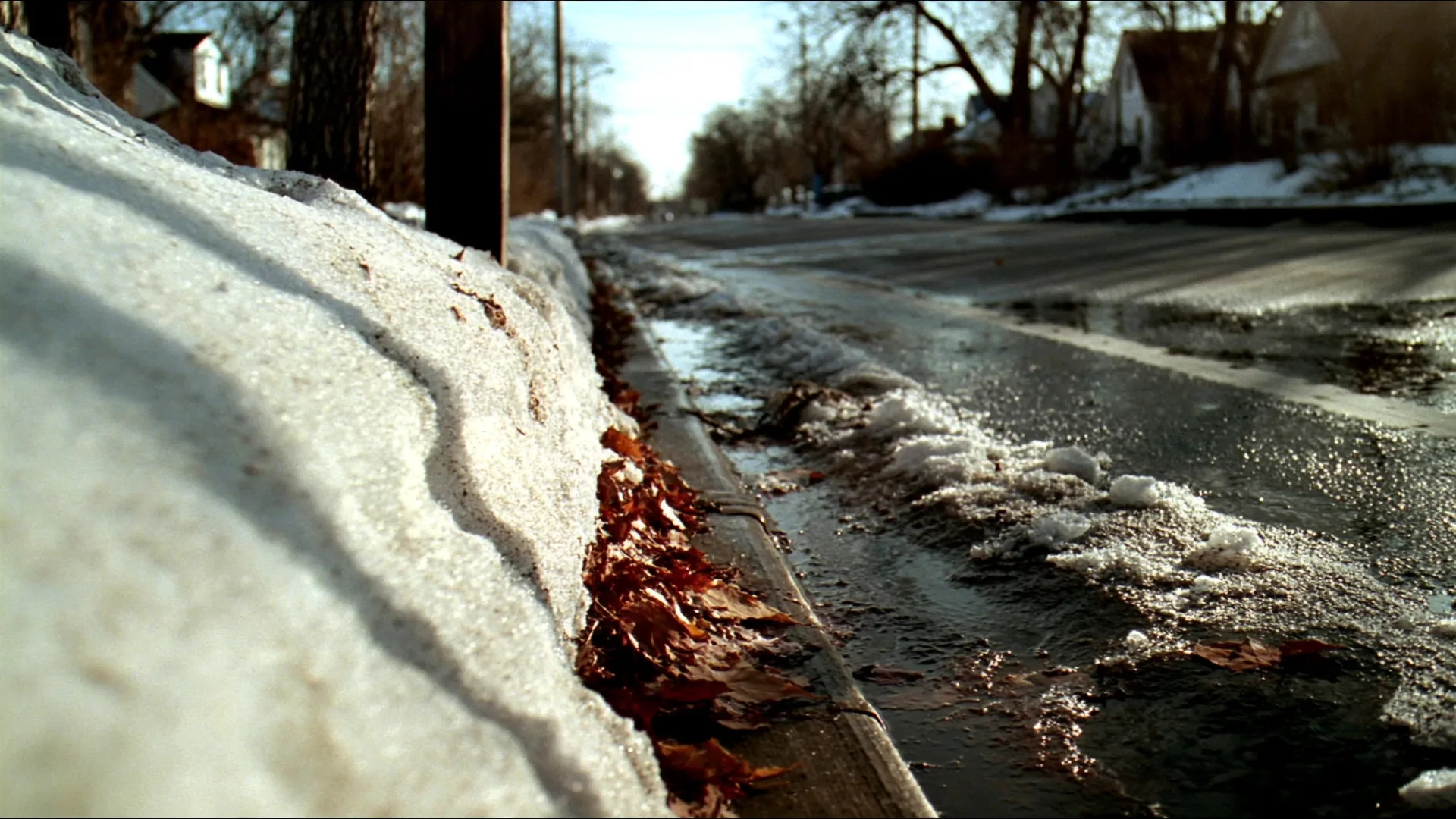Snow melting and running along a curb during a sudden winter thaw